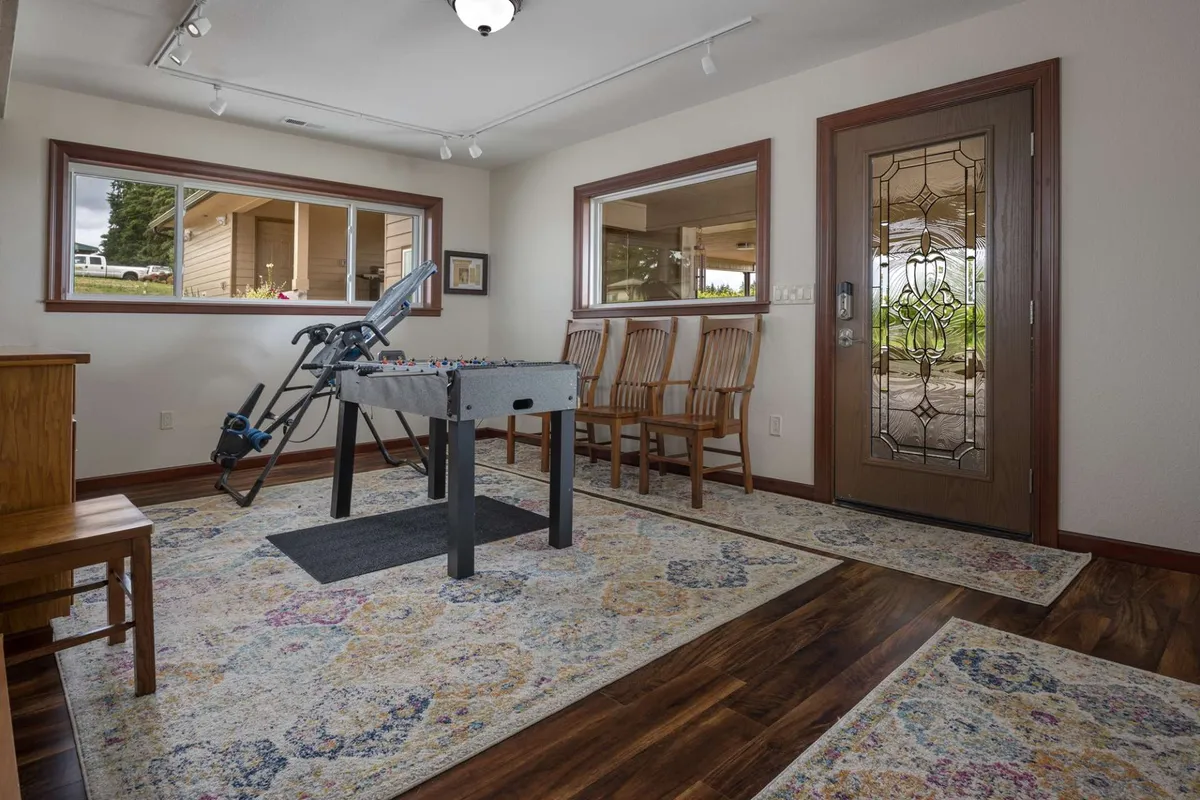 This interior image features a foosball table set in a bright, welcoming space with wooden chairs and a decorative rug. The setup invites playful competition and shared moments, highlighting the home's kid-friendly amenities.