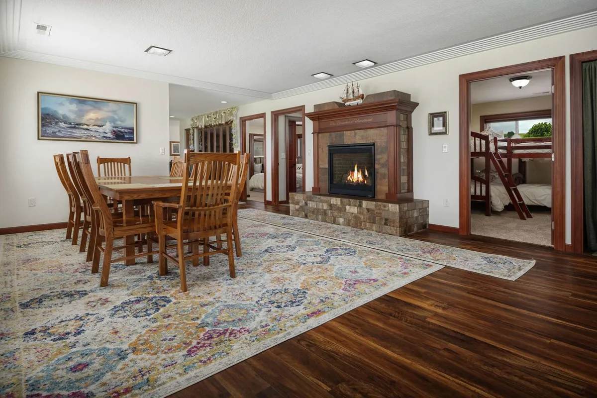 This intimate dining area features a fireplace as its focal point, with a dining table set for family-style meals or game nights. Warm lighting and a decorative rug create a cozy, communal vibe, perfect for sharing stories or unwinding after a day of vineyard adventures.